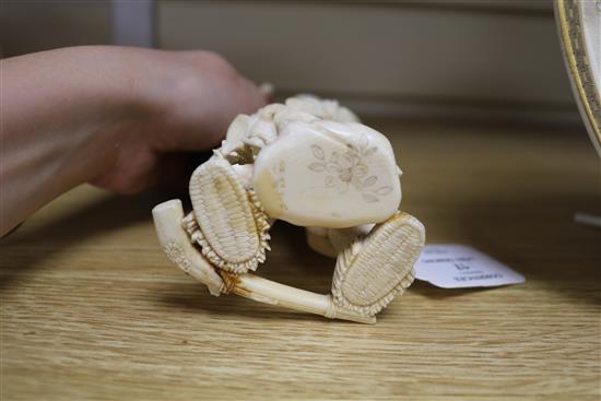 A Japanese carved ivory okimono of a huntsman, Meiji period, holding a hawk and a brace of birds